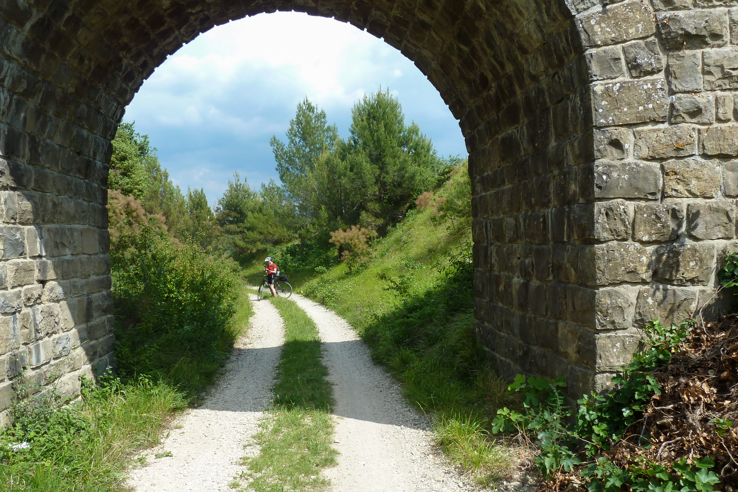 Radfahrer unter dem Steinbogen der Parenzana